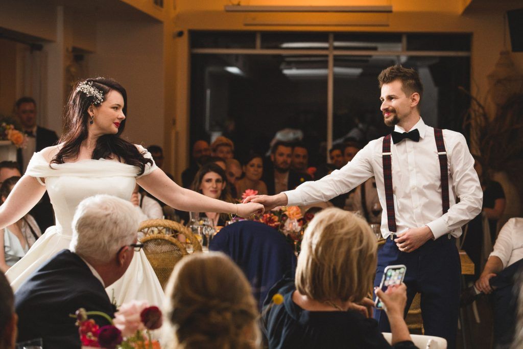 Wedding reception celebration with guests dancing and enjoying festivities in an indoor venue.