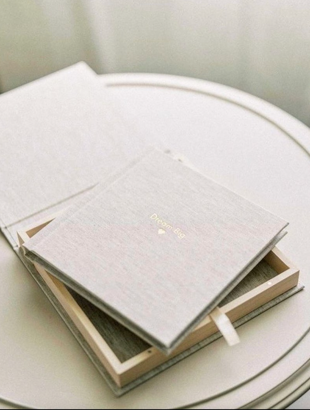 White linen wedding album or photo book displayed on light surface.