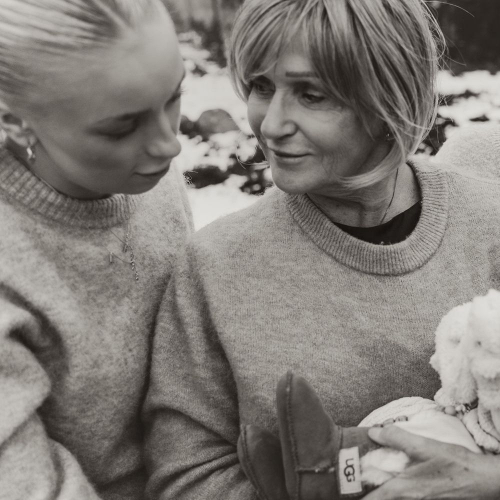 A intimate black and white photo of two people in sweaters sharing a tender moment.