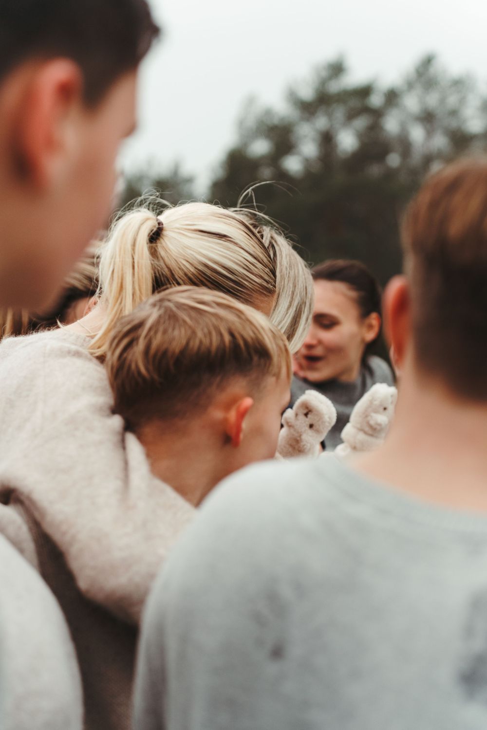 A close-up view of people huddled together looking at something in their midst.