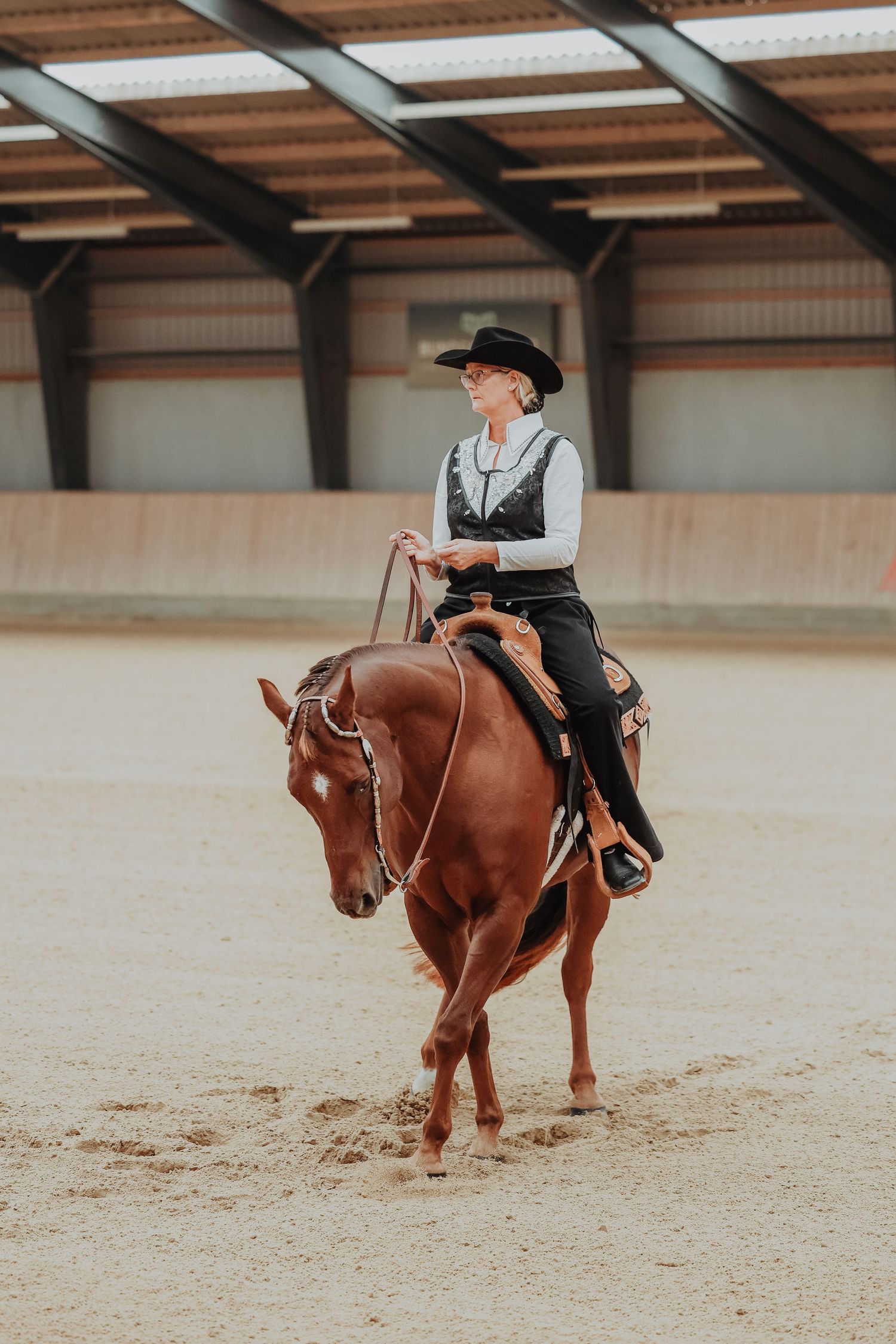 Chestnut horse and rider executing precise movements in a western riding class.