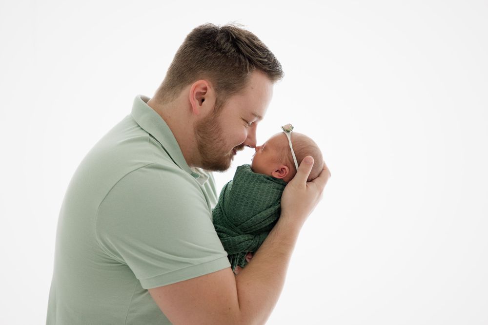 Intimate moment captured against white background showing gentle embrace.