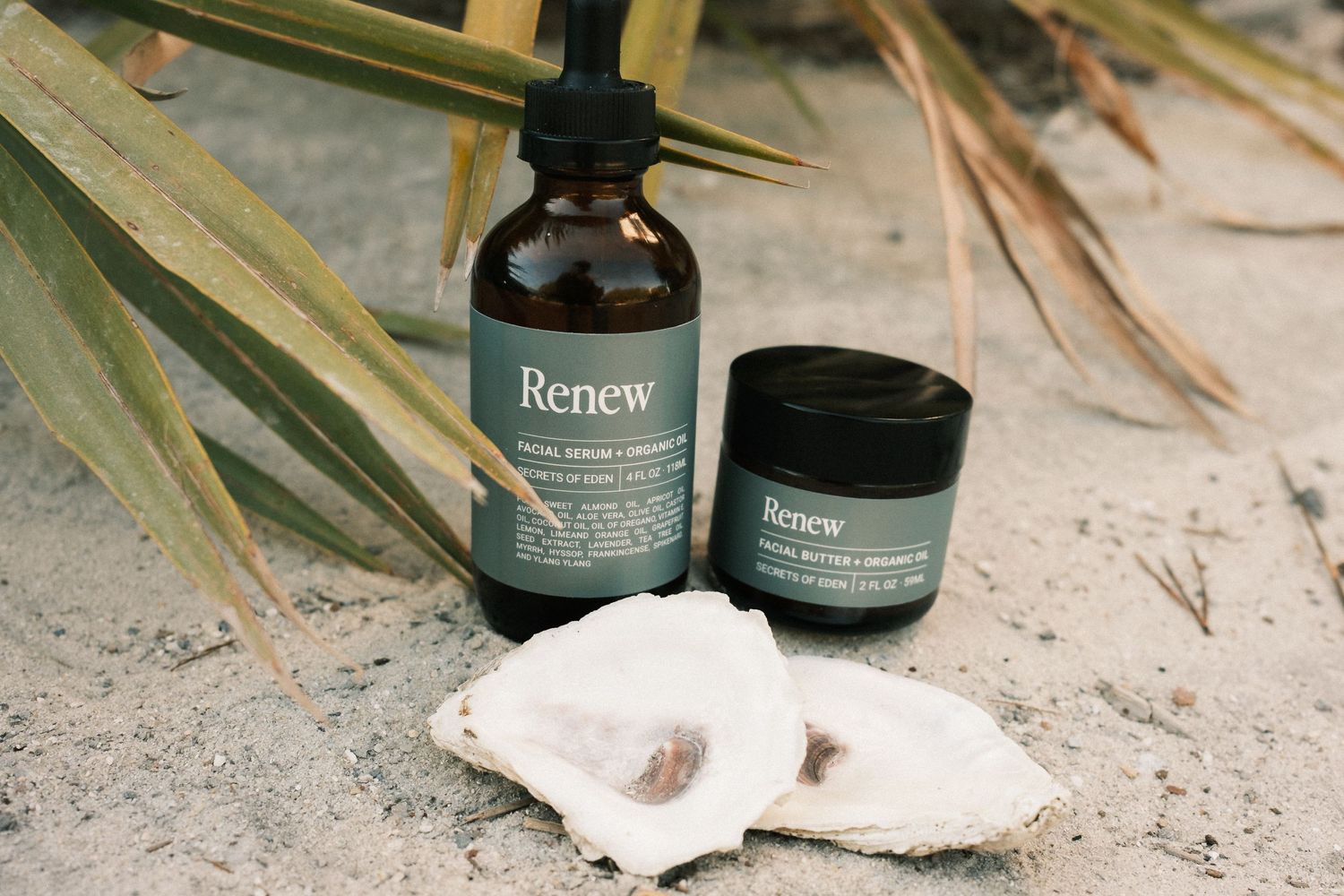 Natural spa products and essential oil bottles arranged with dried palm leaves.