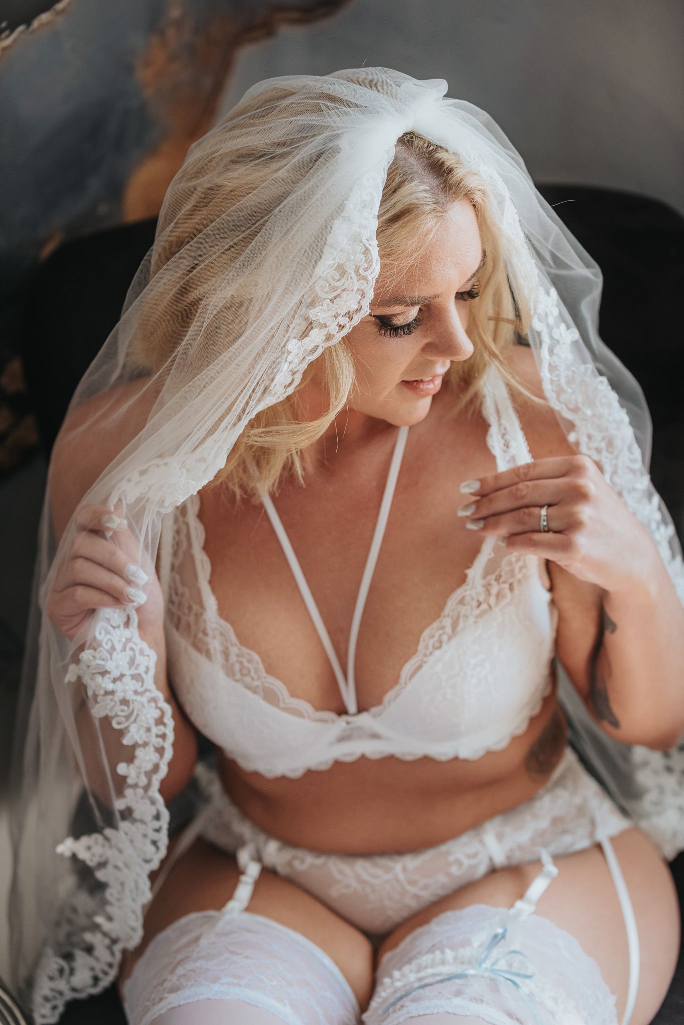 Brud med brudslöja i boudoir by Janes studio fotograferas till hennes morgongåva.