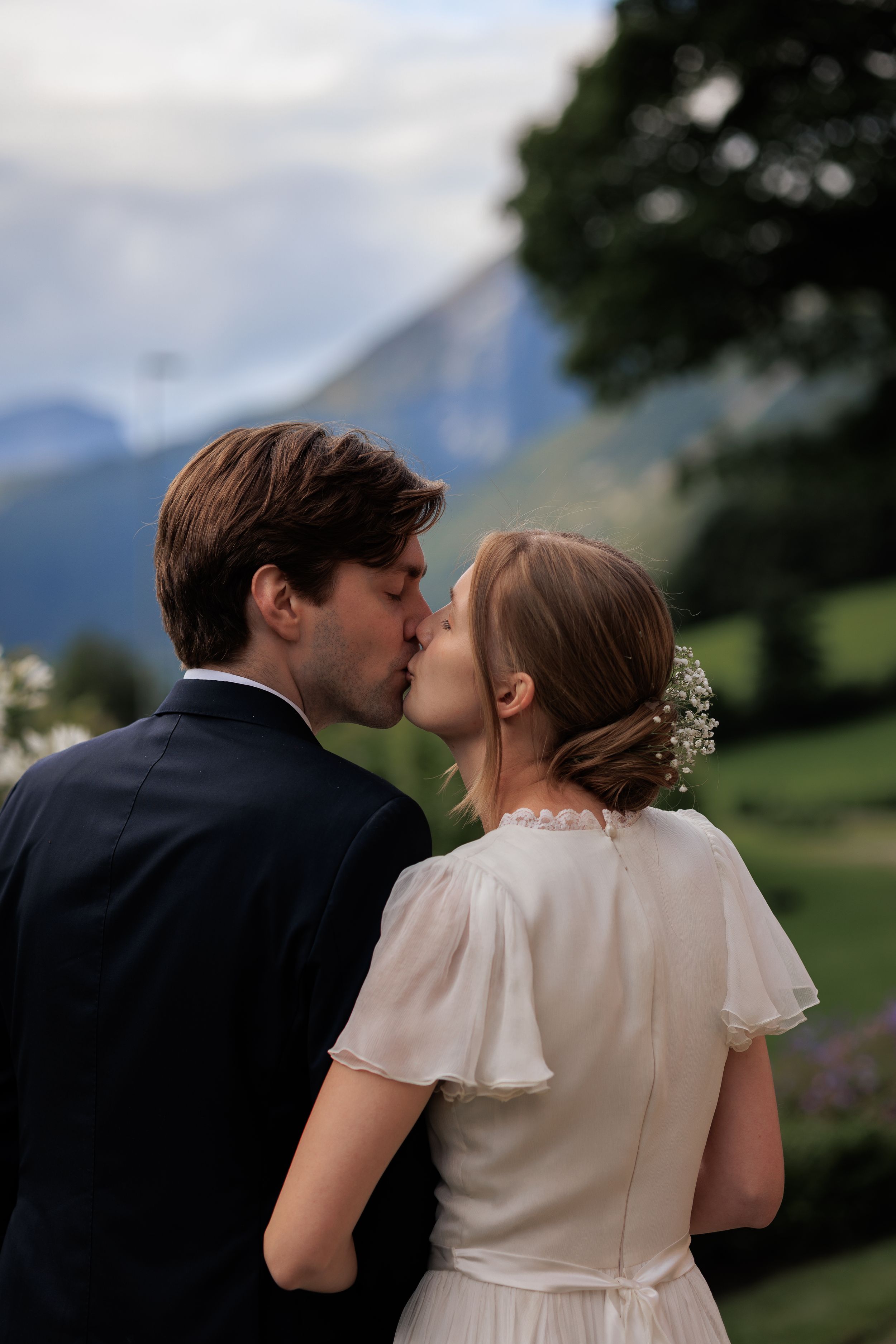 A romantic wedding portrait with mountains in the background during golden hour.