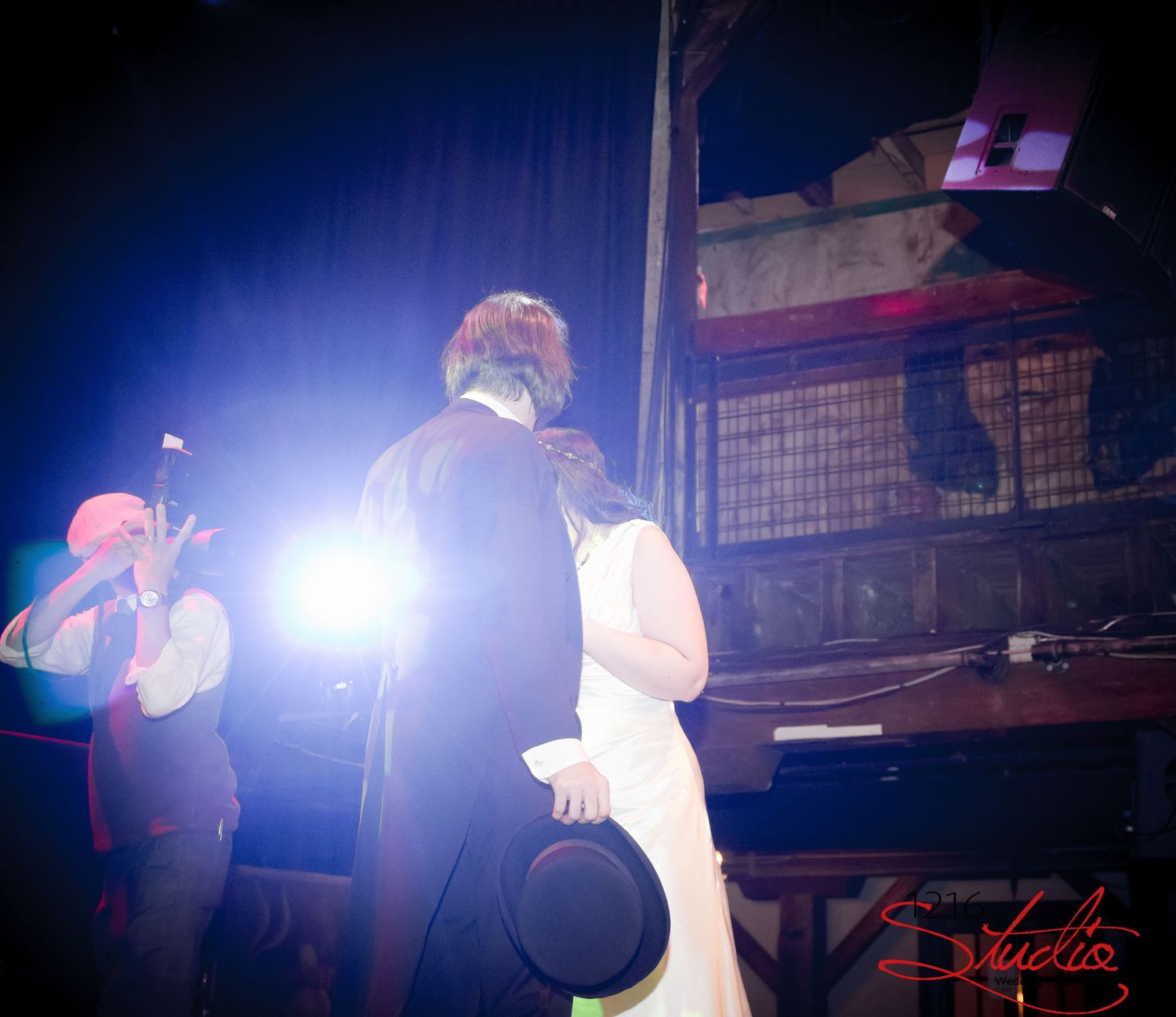 Concert performance with dramatic stage lighting creating silhouettes against a blue background.