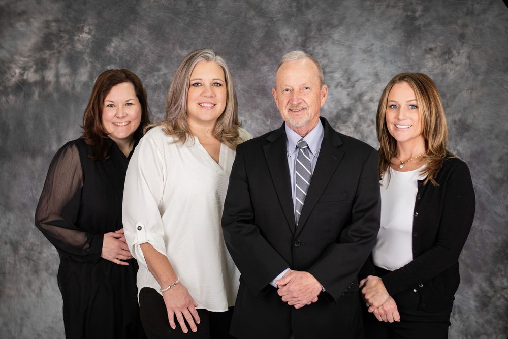 Professional studio portrait of family group against grey backdrop.