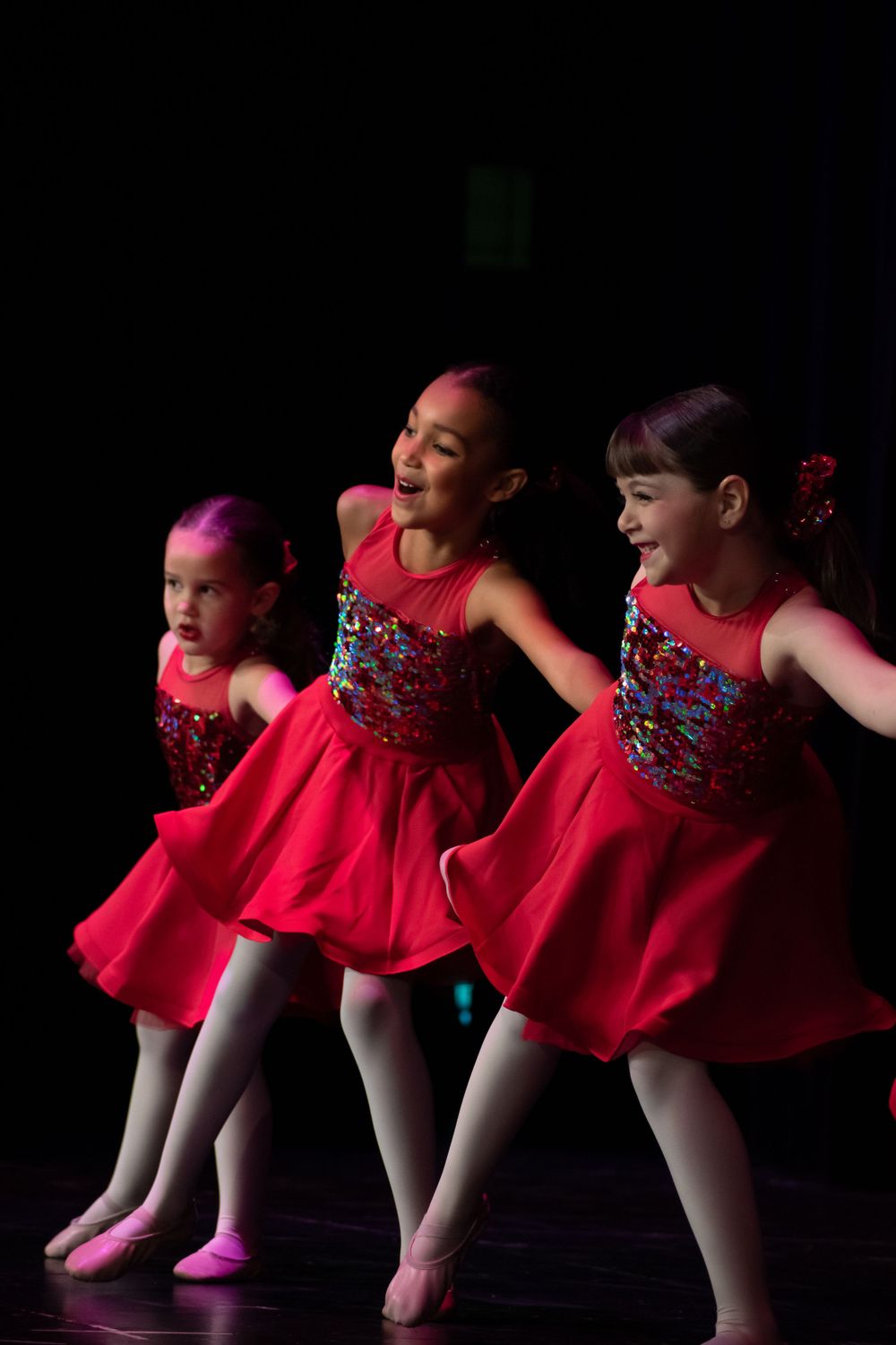 Dance group in matching red costumes performs synchronized routine.