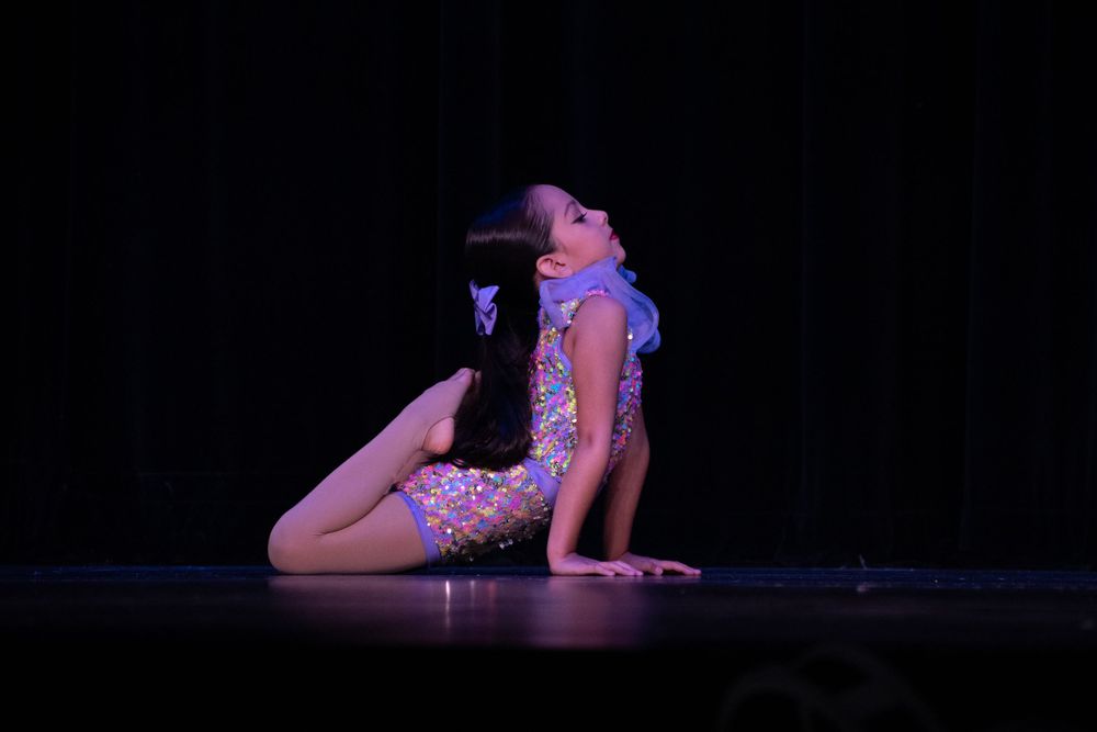 Solo dance performance on dimly lit stage.