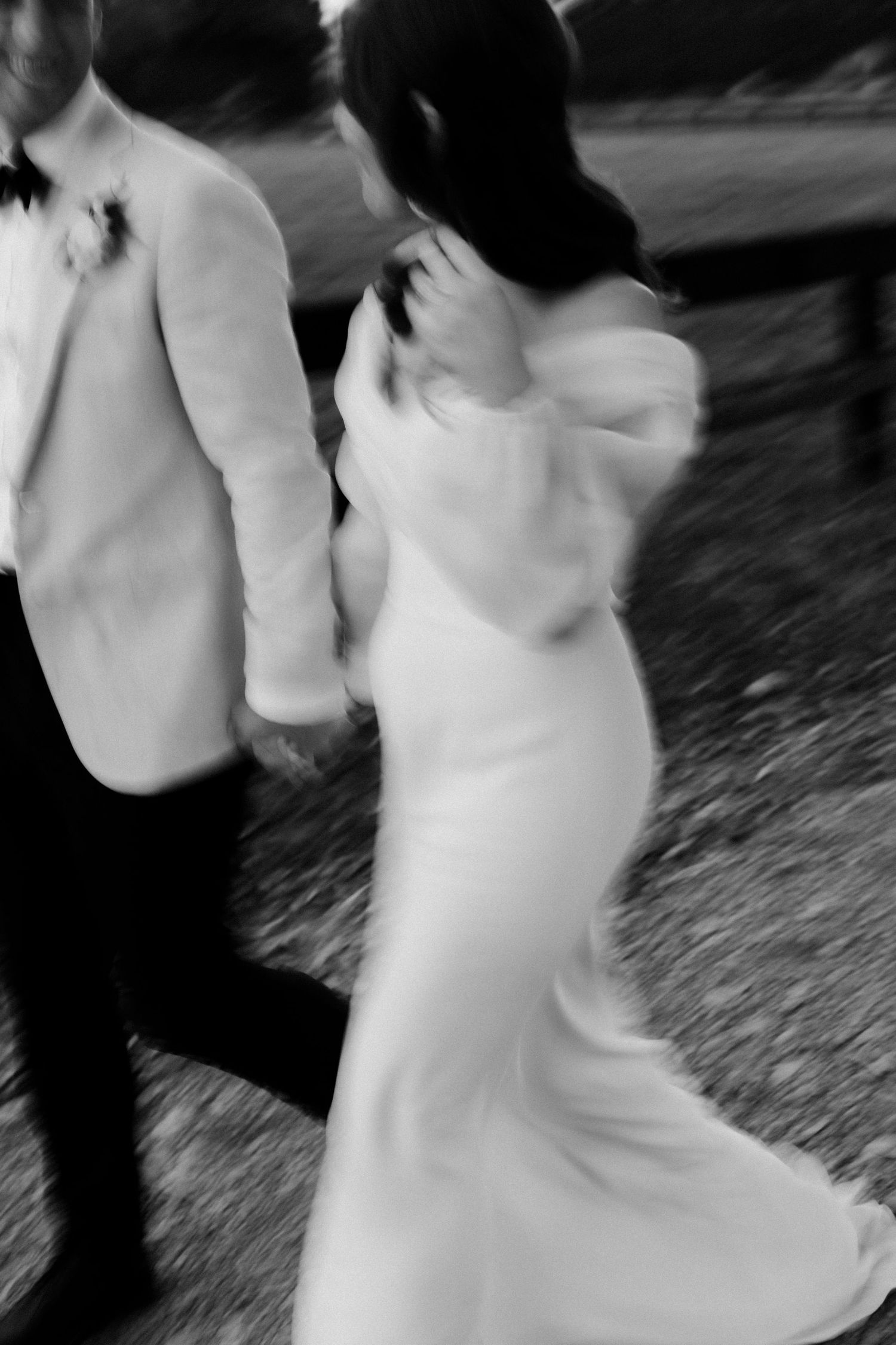 Motion-blurred black and white photo of couple dancing at their wedding.
