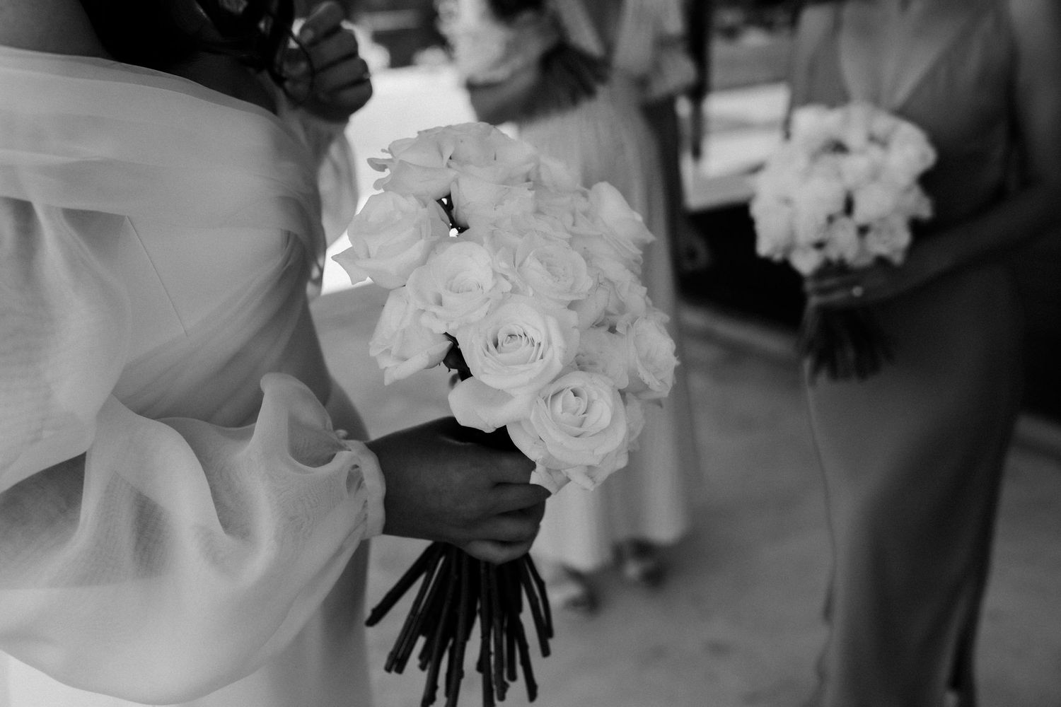 Black and white photo of white rose wedding bouquet being held.