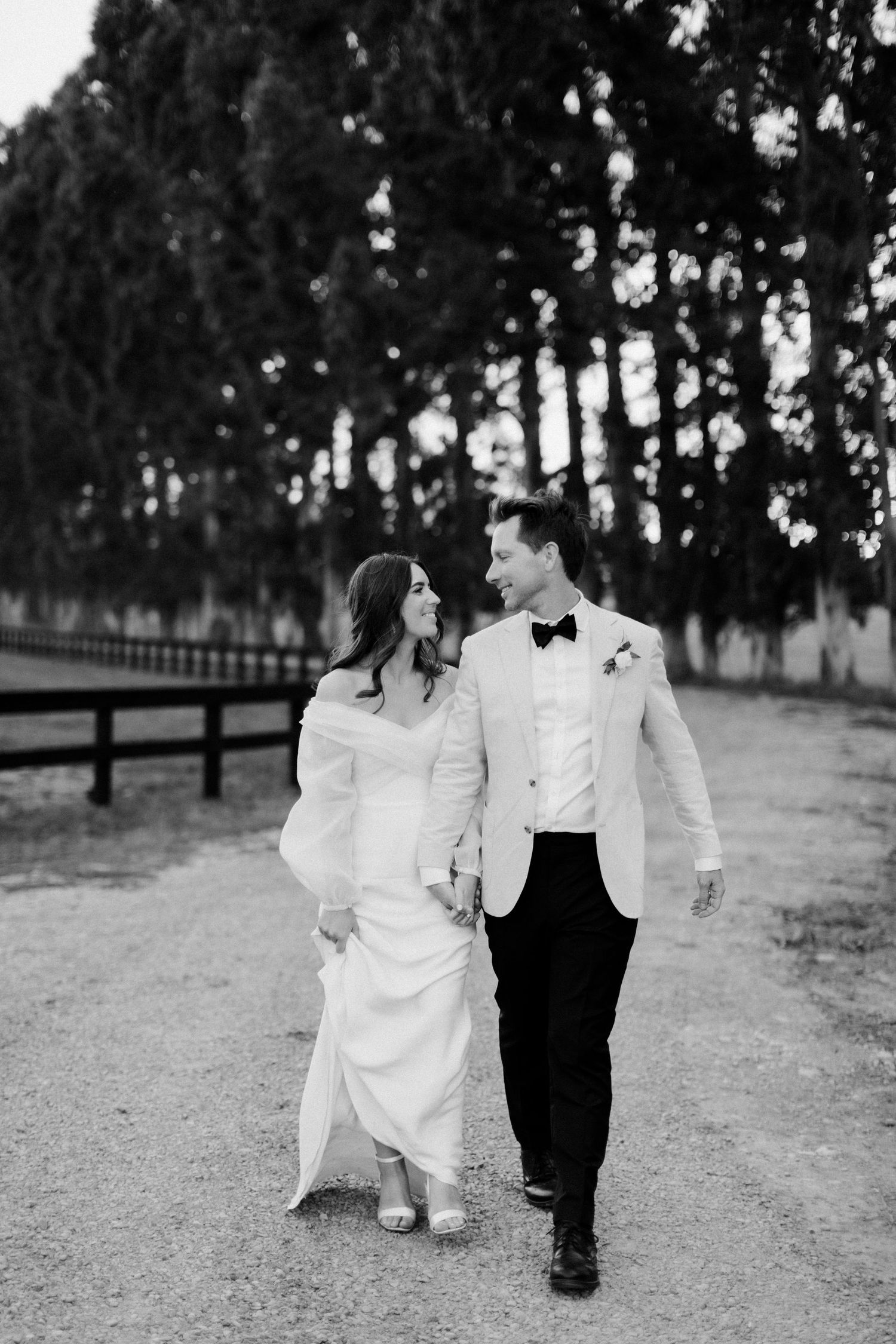 Black and white photo of couple strolling together on a rustic path.