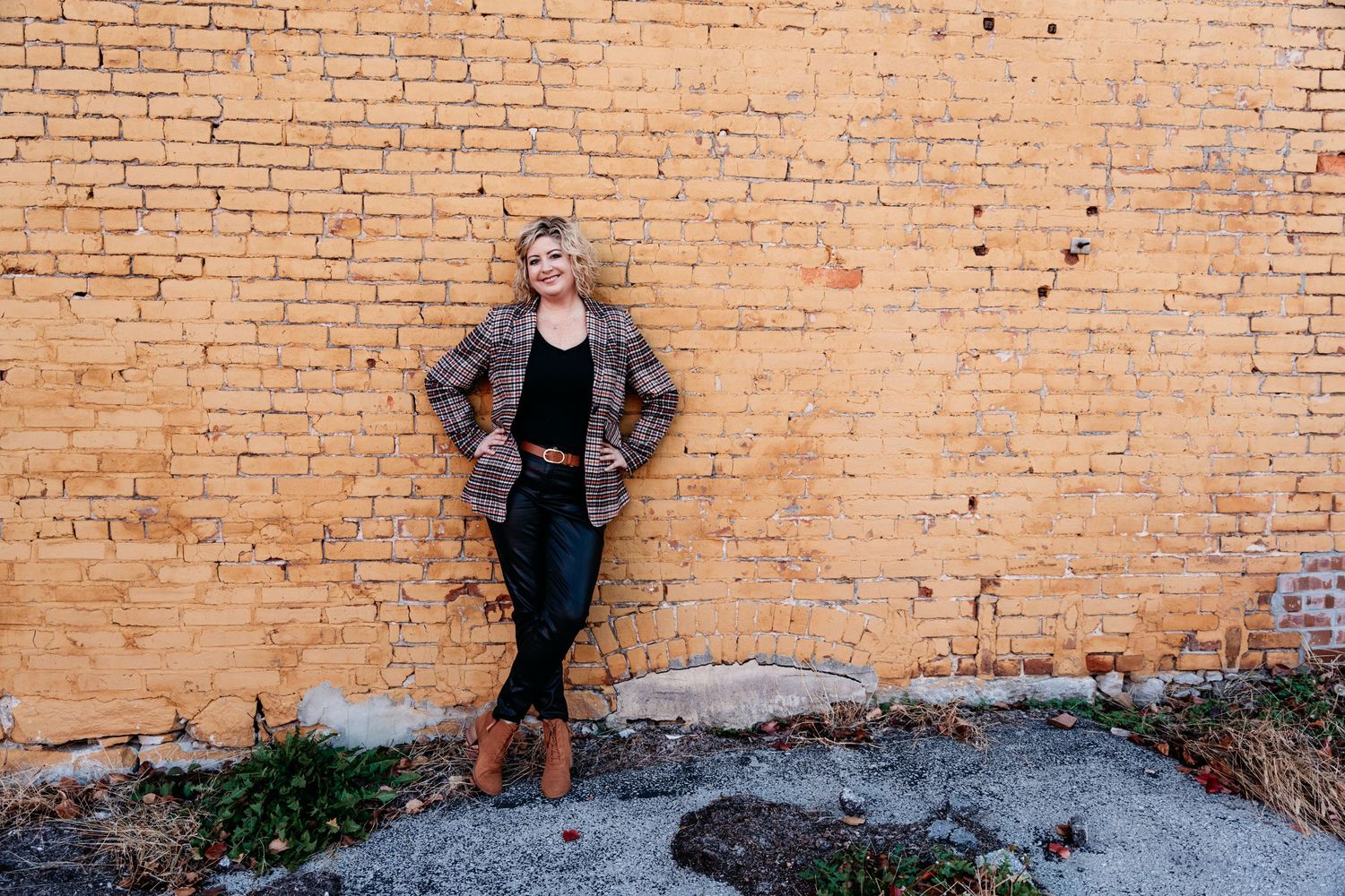 Woman standing against brick wall portrait, Commercial Street