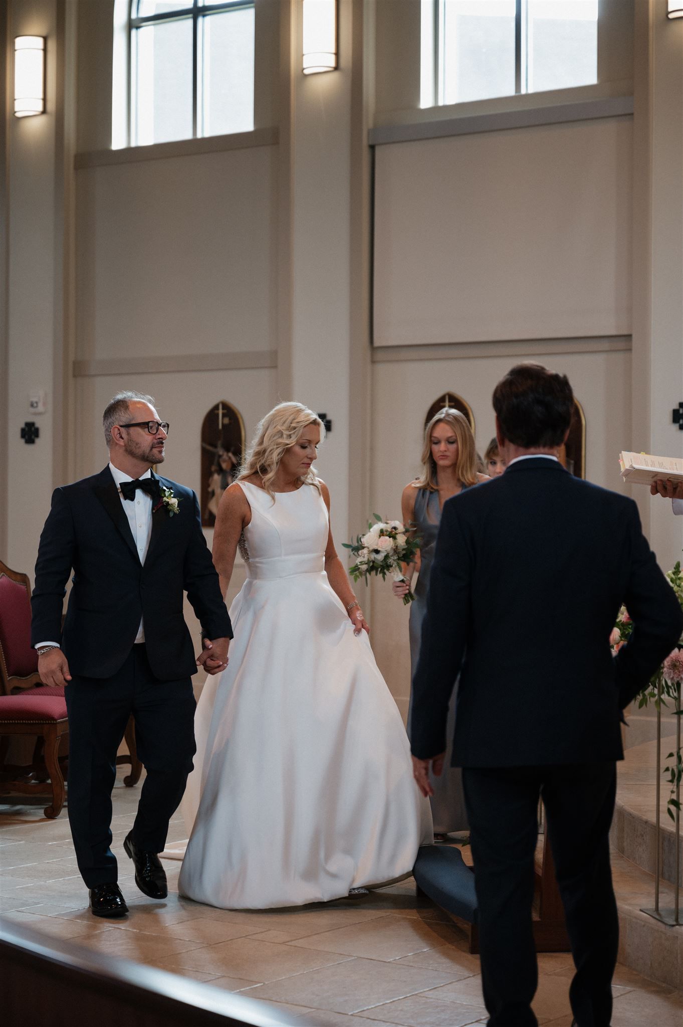 Elegant church wedding ceremony with high ceilings and arched windows.