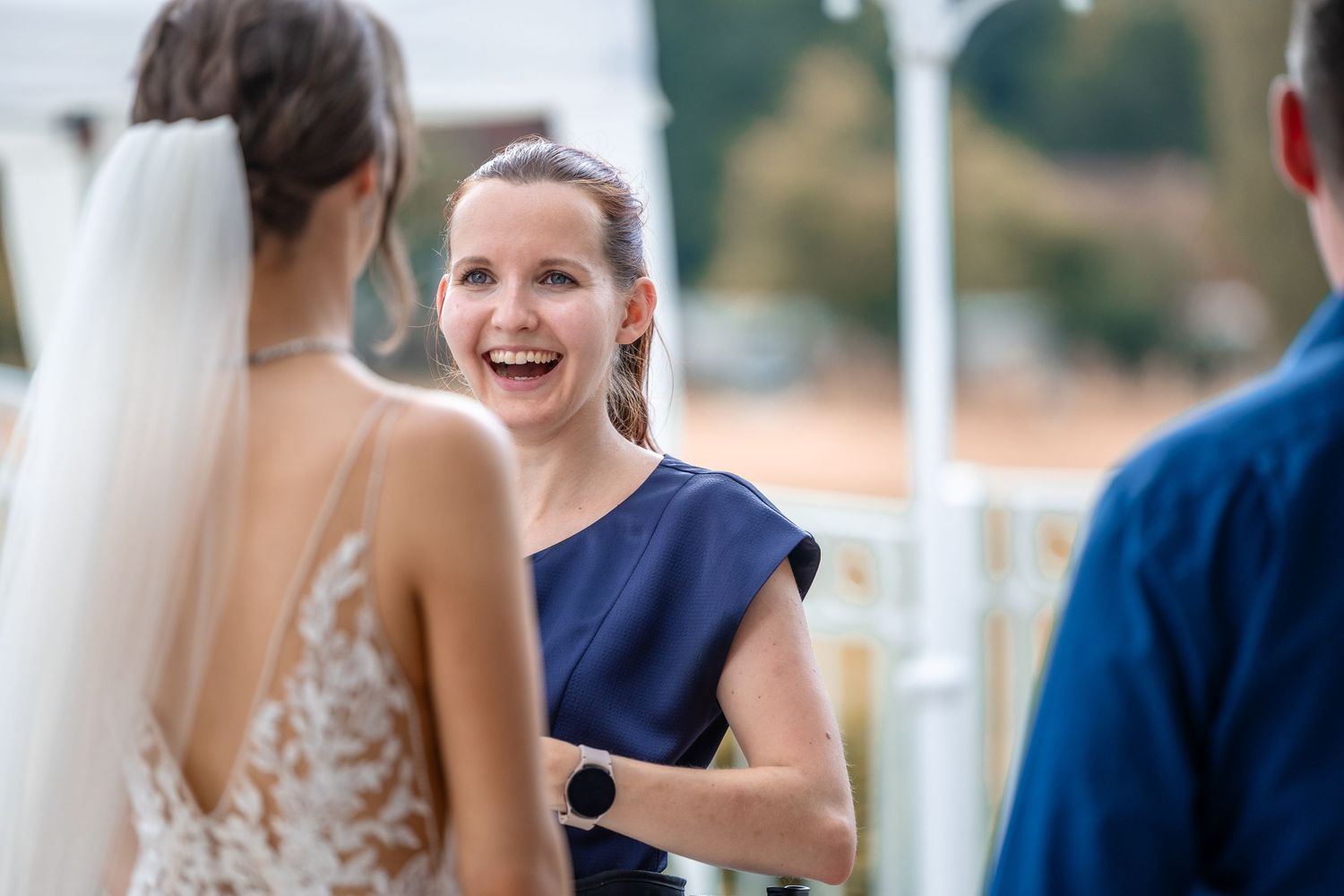 Joy-filled moment captured during an outdoor wedding ceremony with natural lighting.