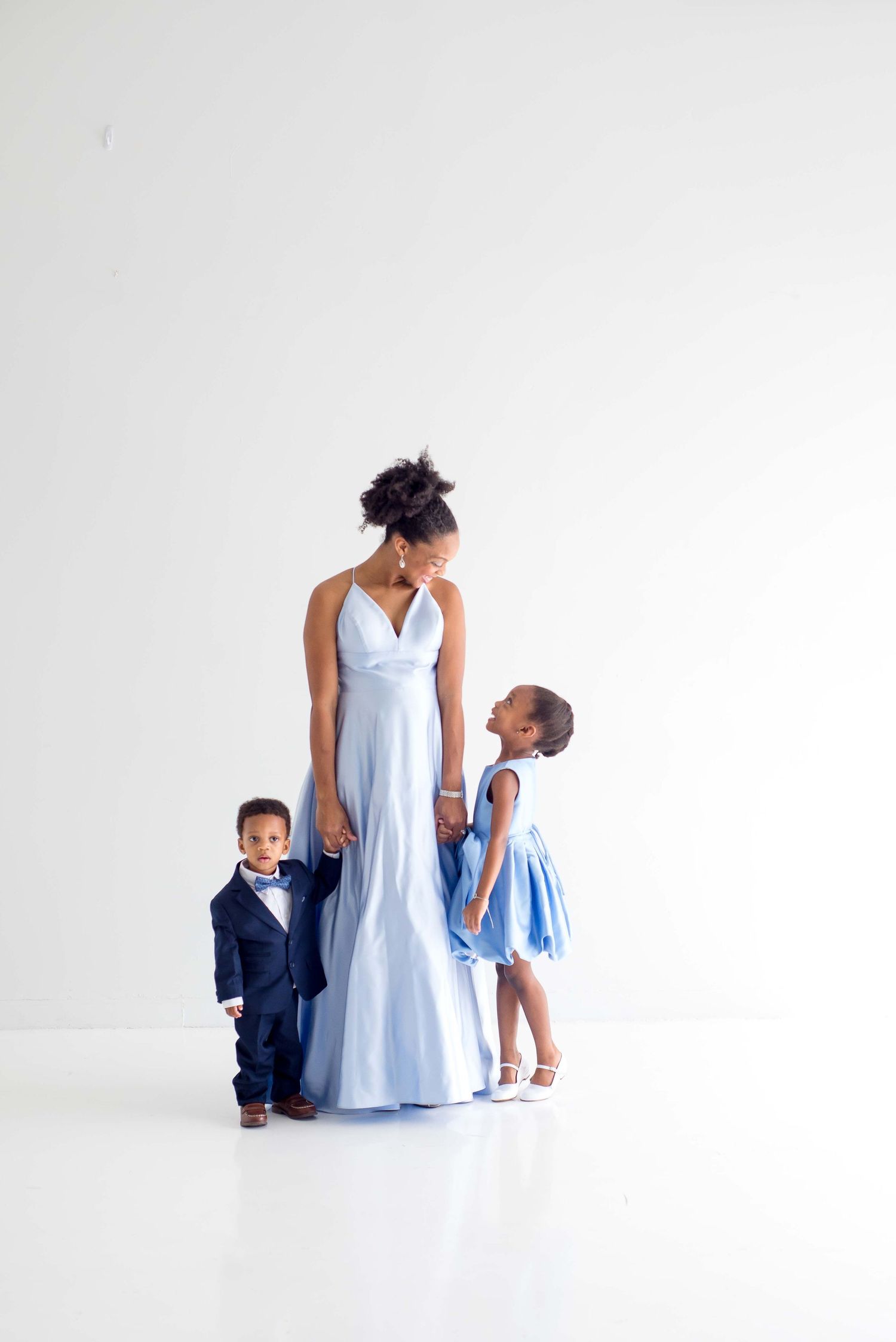 daughter son and mother taking pictures together in a white studio houston texas