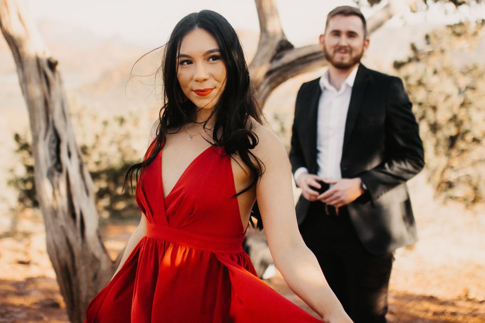 A couple poses in contrasting formal wear against a desert landscape.