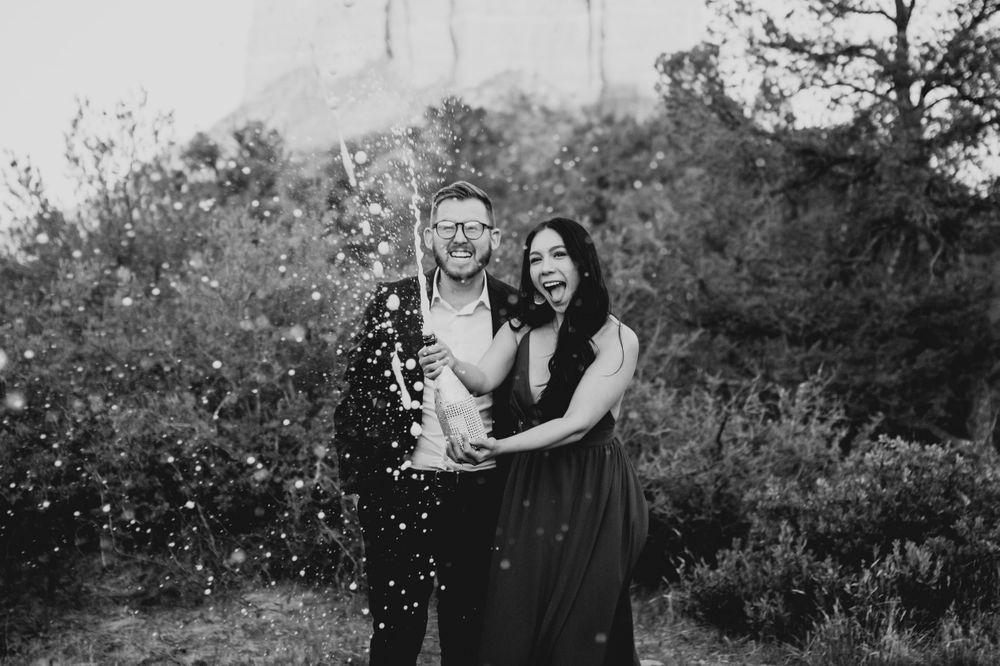 Black and white engagement photos with confetti and natural desert backdrop.