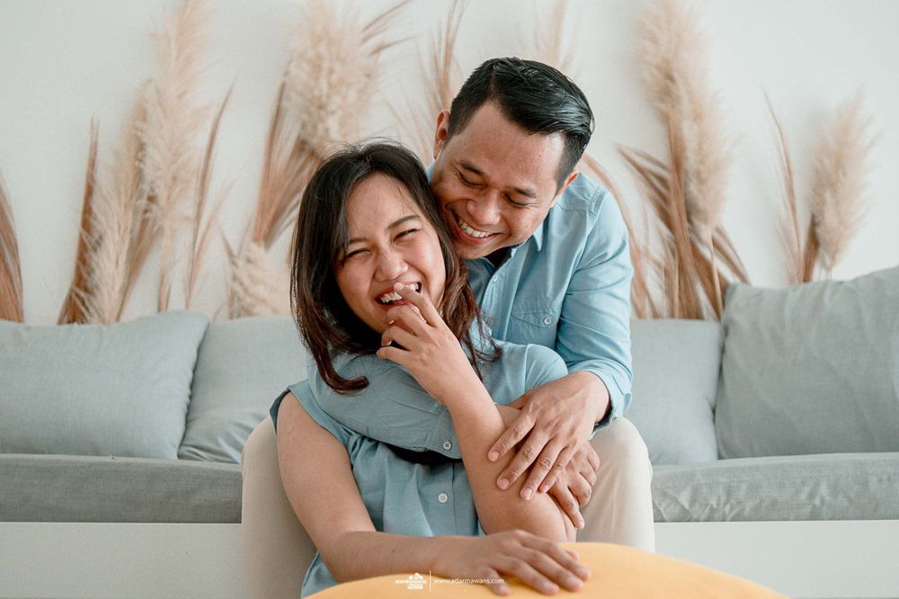 Couple sharing a playful intimate moment while sitting on their couch.