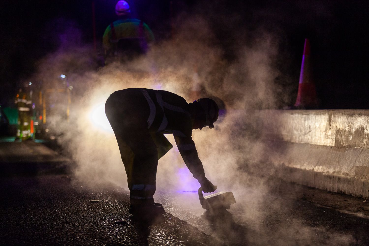 Construction photograph of tarmac laying on A1, man in silhouette