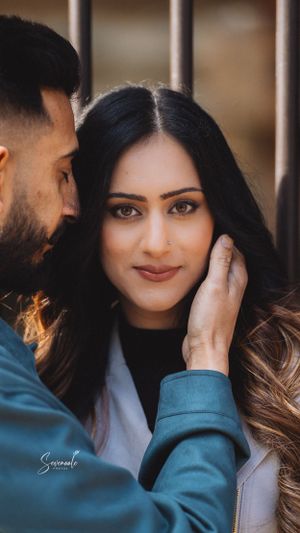 An intimate portrait of a couple sharing a tender moment against a blurred background.