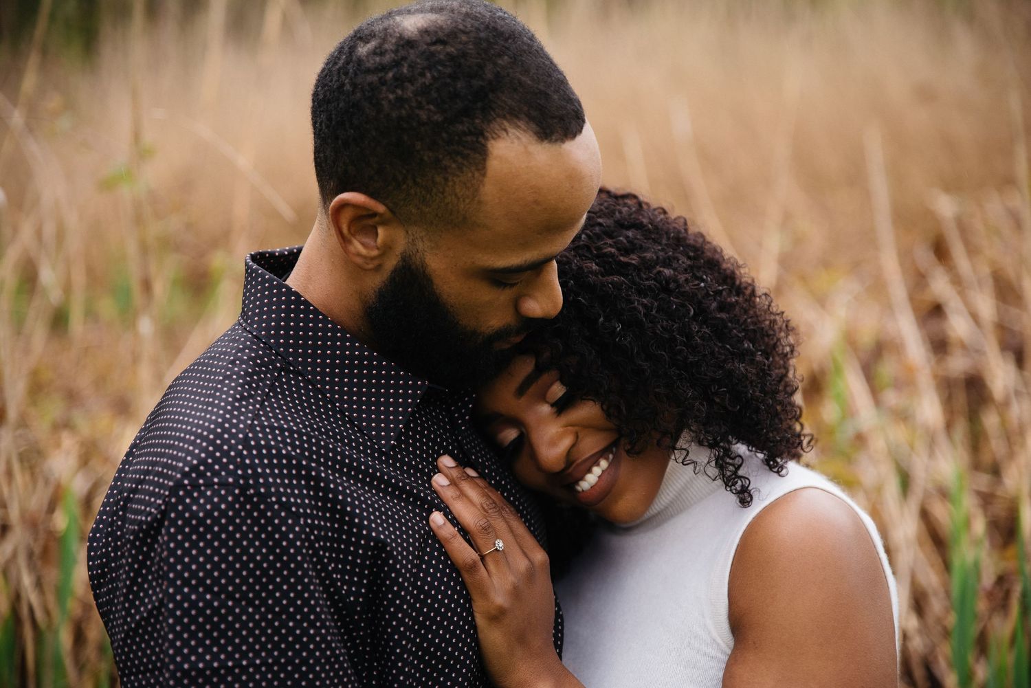 An intimate couple's portrait in a wheat field showing tender affection.