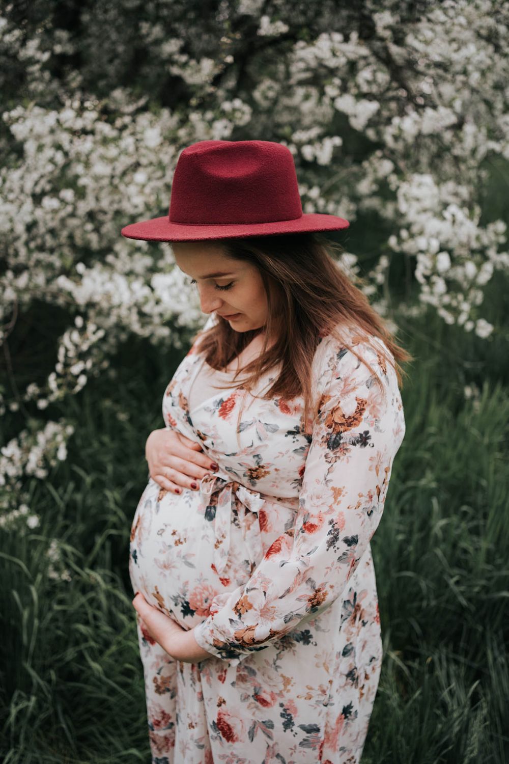 przyszła mama pod kwitnącym drzewem -  fotograf ciążowy Kraków