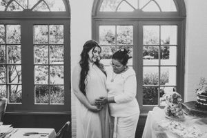 A touching maternity moment captured in black and white by elegant arched windows.