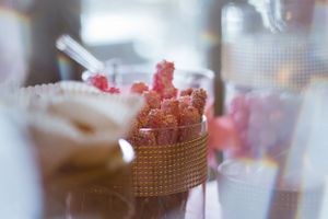 Close-up of candied bacon appetizers served in a metallic mesh container.