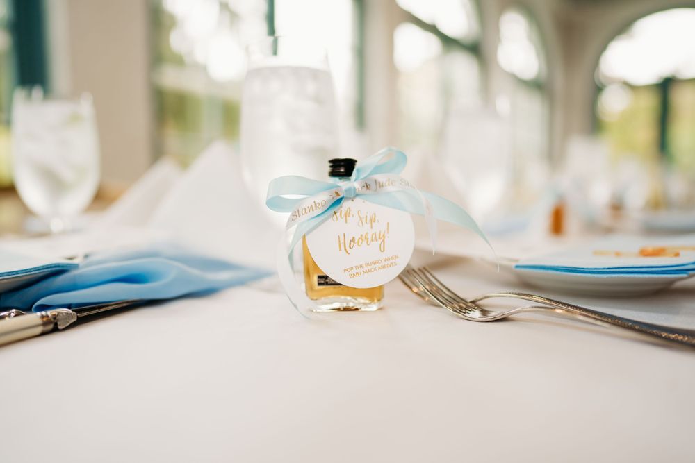 Small baby shower favor bottle with light blue ribbon and custom tag on elegant place setting in the Hudson Valley,NY.