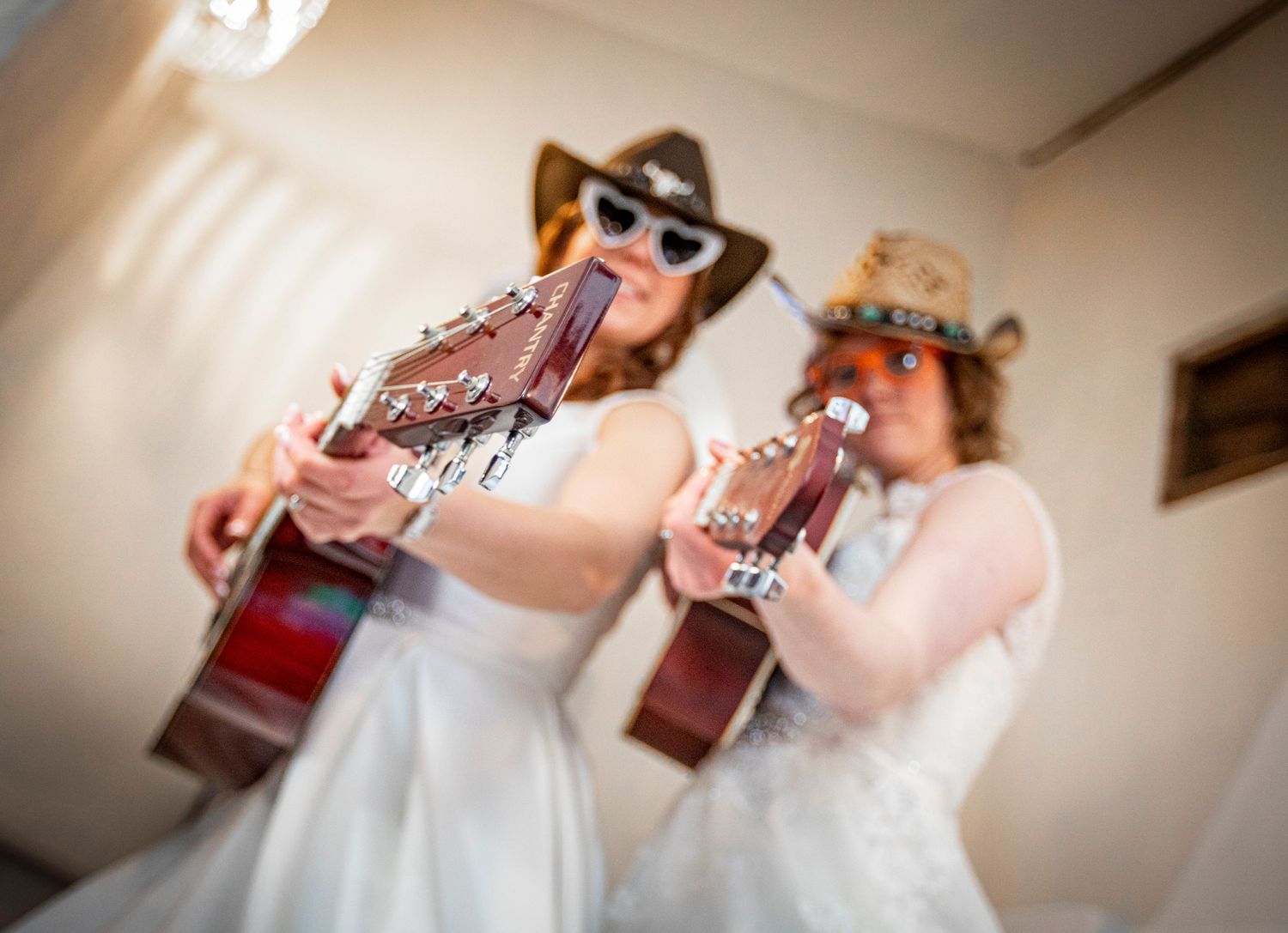 Bride in white dress playing violin during wedding celebration.