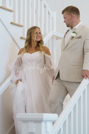 Bride and groom gazing at each other as they descend the stairway