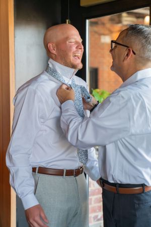 Father helping son prepare for his wedding