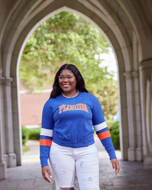 Florida university pride shown through blue and orange athletic wear under historic archway.
