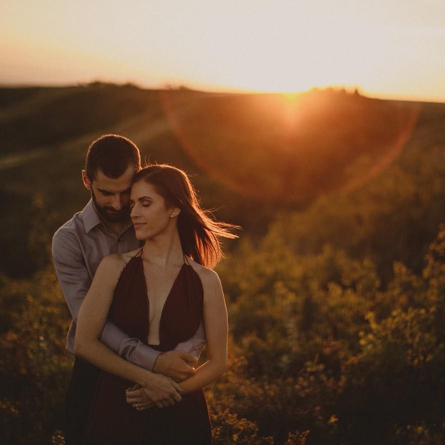 Golden hour engagement portrait with dramatic sunset lighting in natural setting.