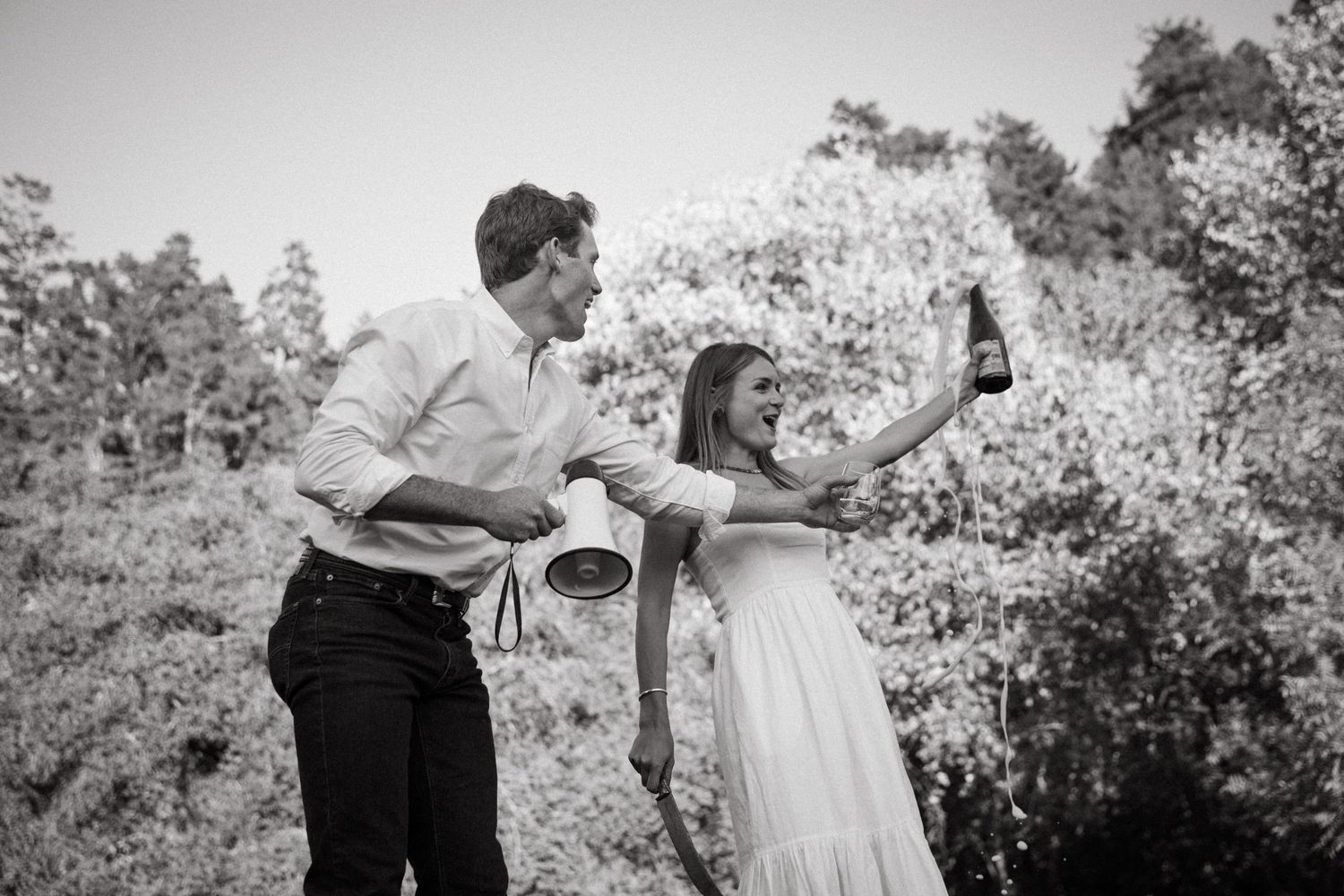Playful moment captured in black and white with spring blossoms in the background.
