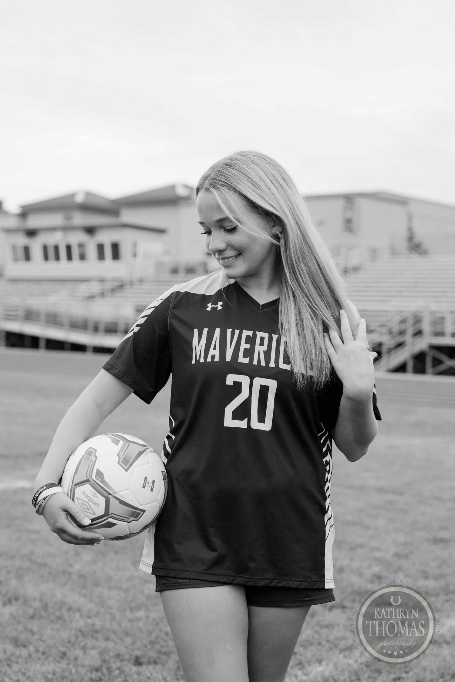 Black and white photo of athlete in Mavericks jersey holding soccer ball.