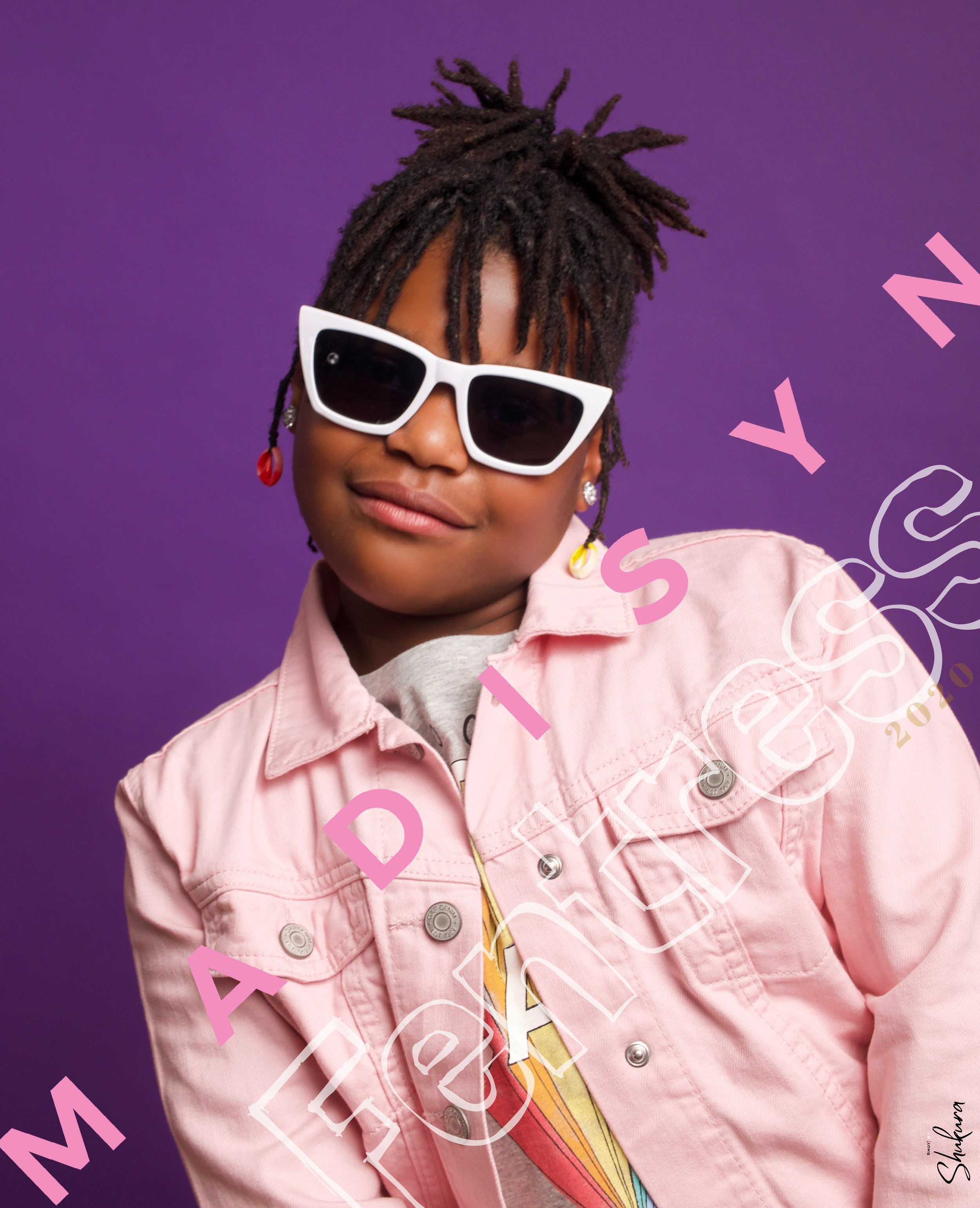 Fashion portrait with white sunglasses and pink jacket against purple background with text overlay.