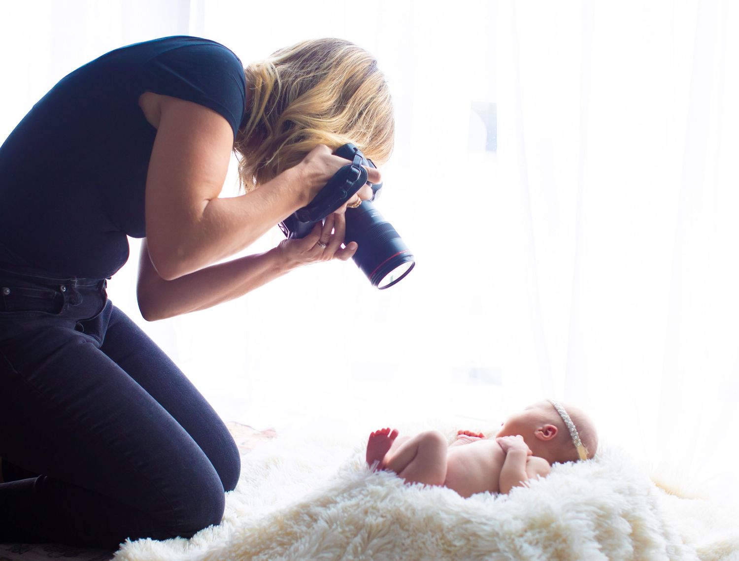Professional photographer working with camera in bright studio setting.