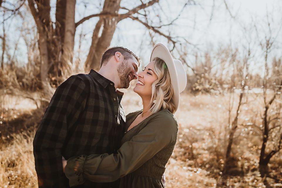 Couple sharing intimate moment together in winter woods setting.