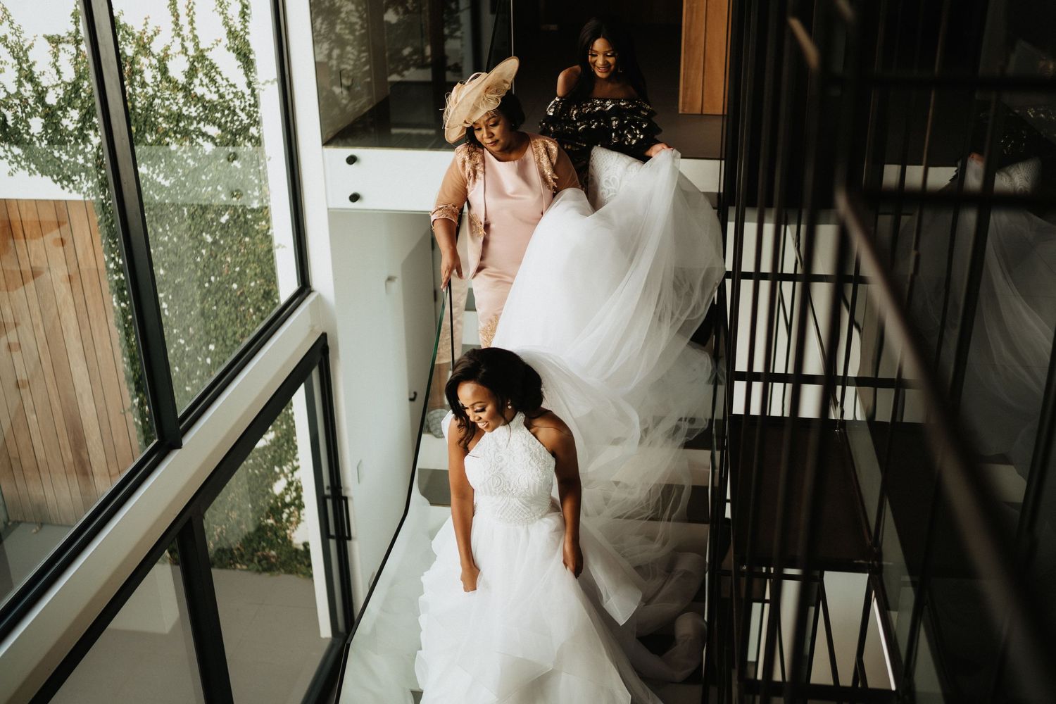 Wedding preparations on a modern staircase with flowing white dresses.