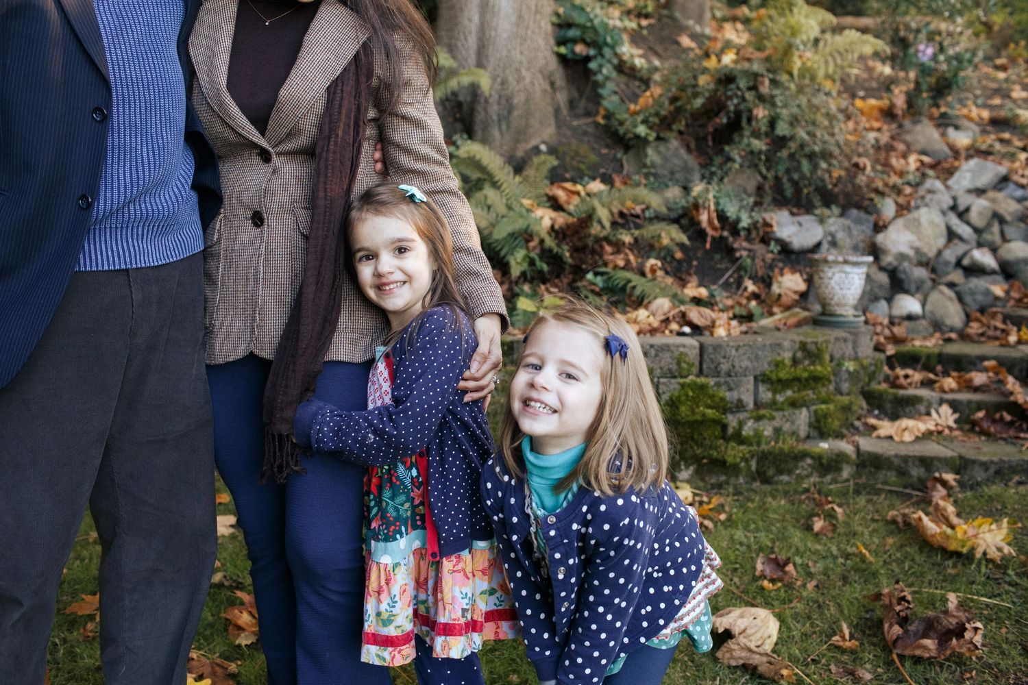 Mukilteo family photography: two young girls stand next to their parents at a photo session on Mukilteo