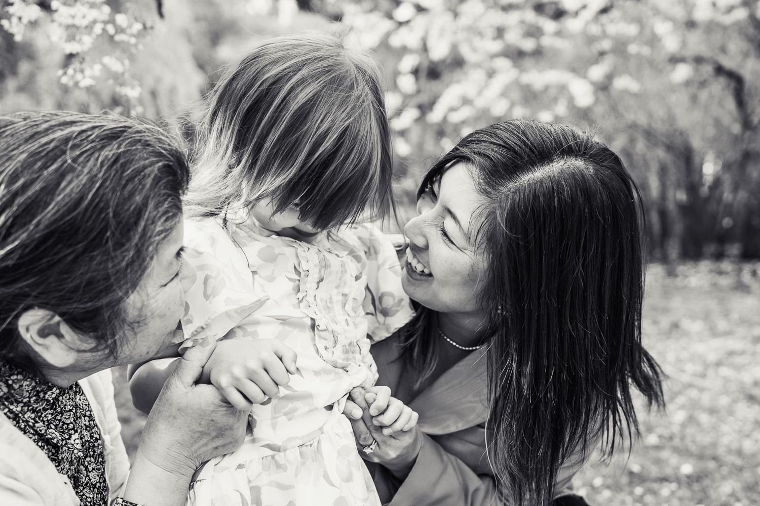 Black and white image of mother laughing with daughter in the spring