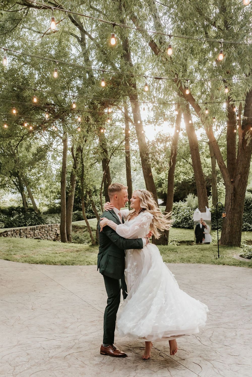 Alpine Art Center wedding couple shares romantic dance moves under tree canopy with twinkling lights.