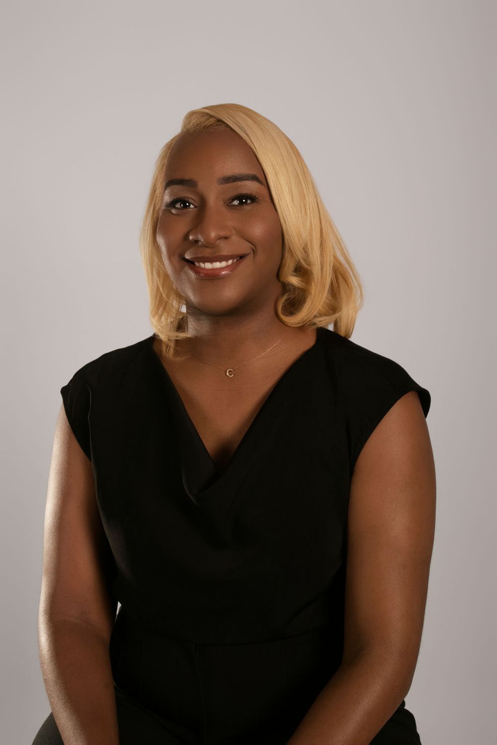Studio portraits featuring elegant poses in a black sleeveless top with blonde hair styling.