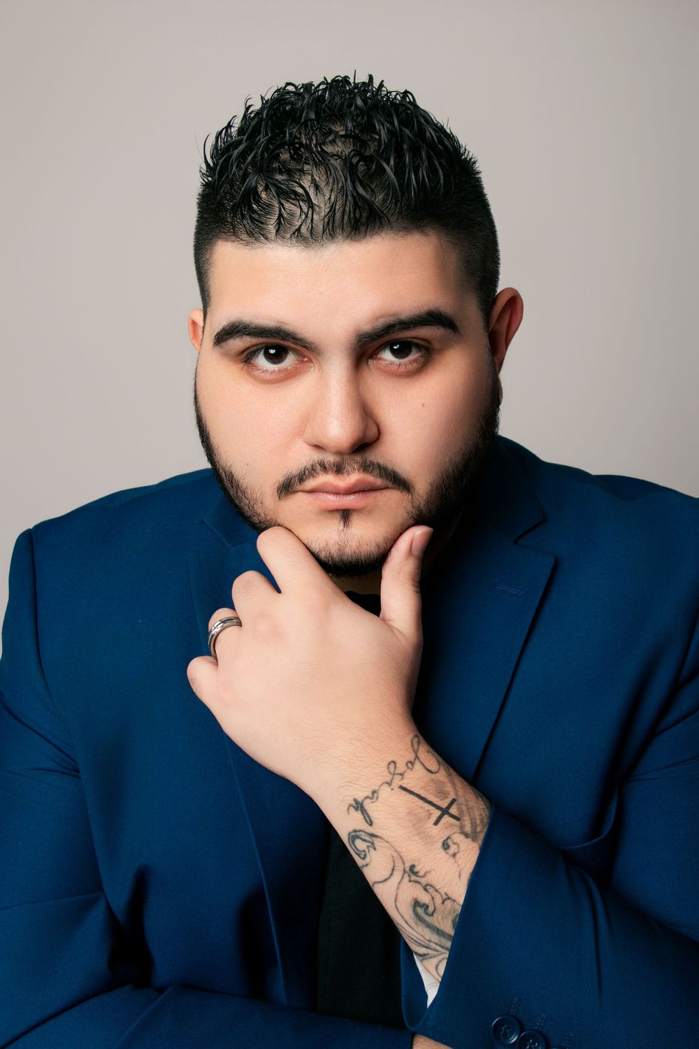 Close-up headshots showing contemplative poses with hand gestures and navy blazer.