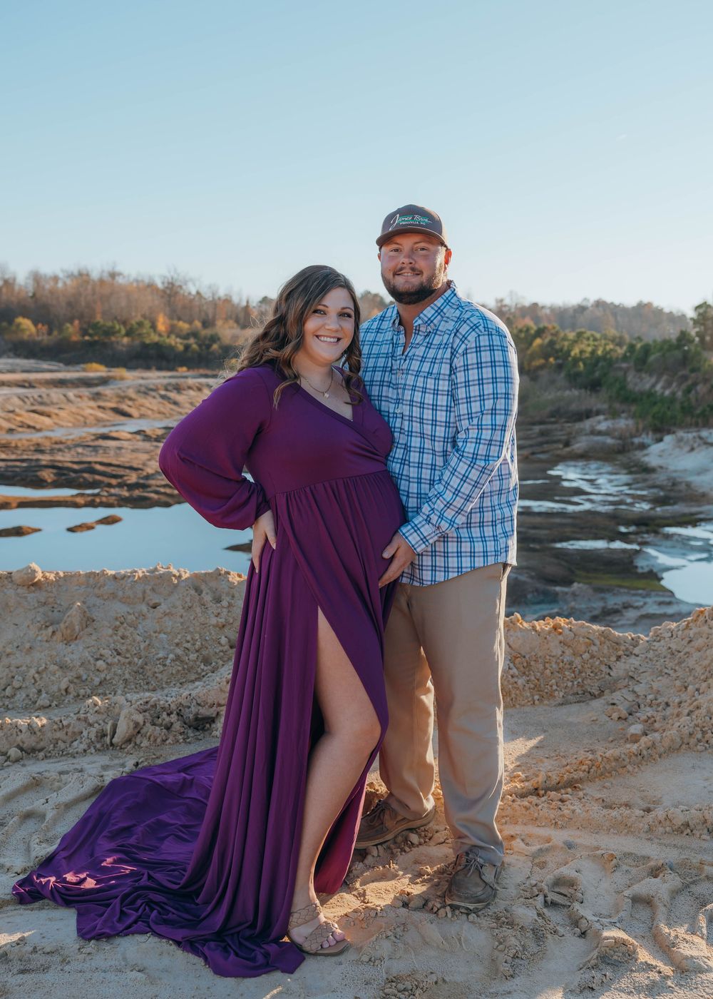 Expecting mother holding baby bump during a glowing maternity photography session with natural light in North Carolina.