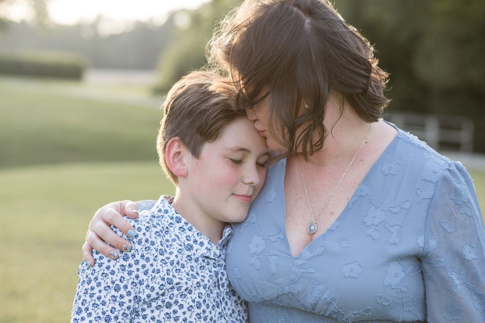 A tender moment between parent and child embracing outdoors during golden hour.