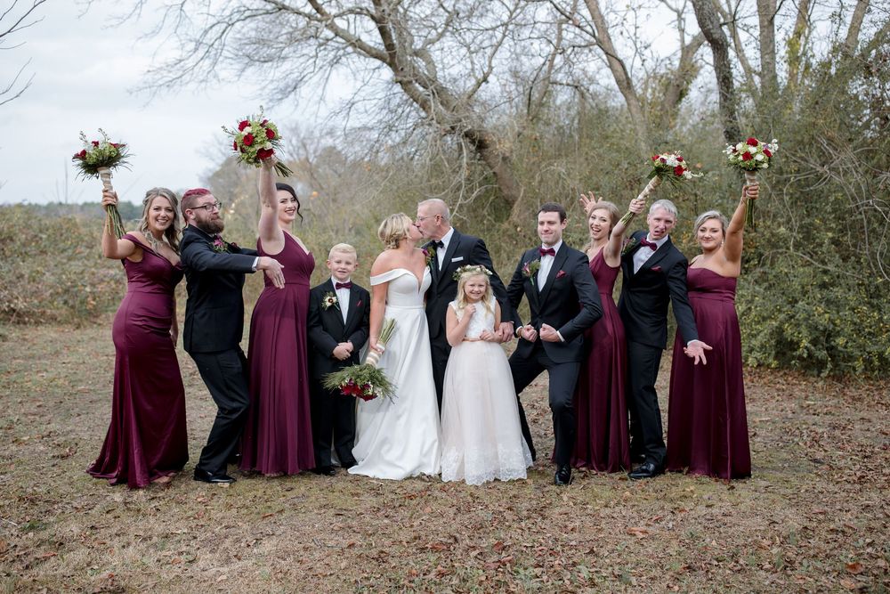 Wedding party in burgundy and white dresses poses together outdoors during fall season. North Carolina.