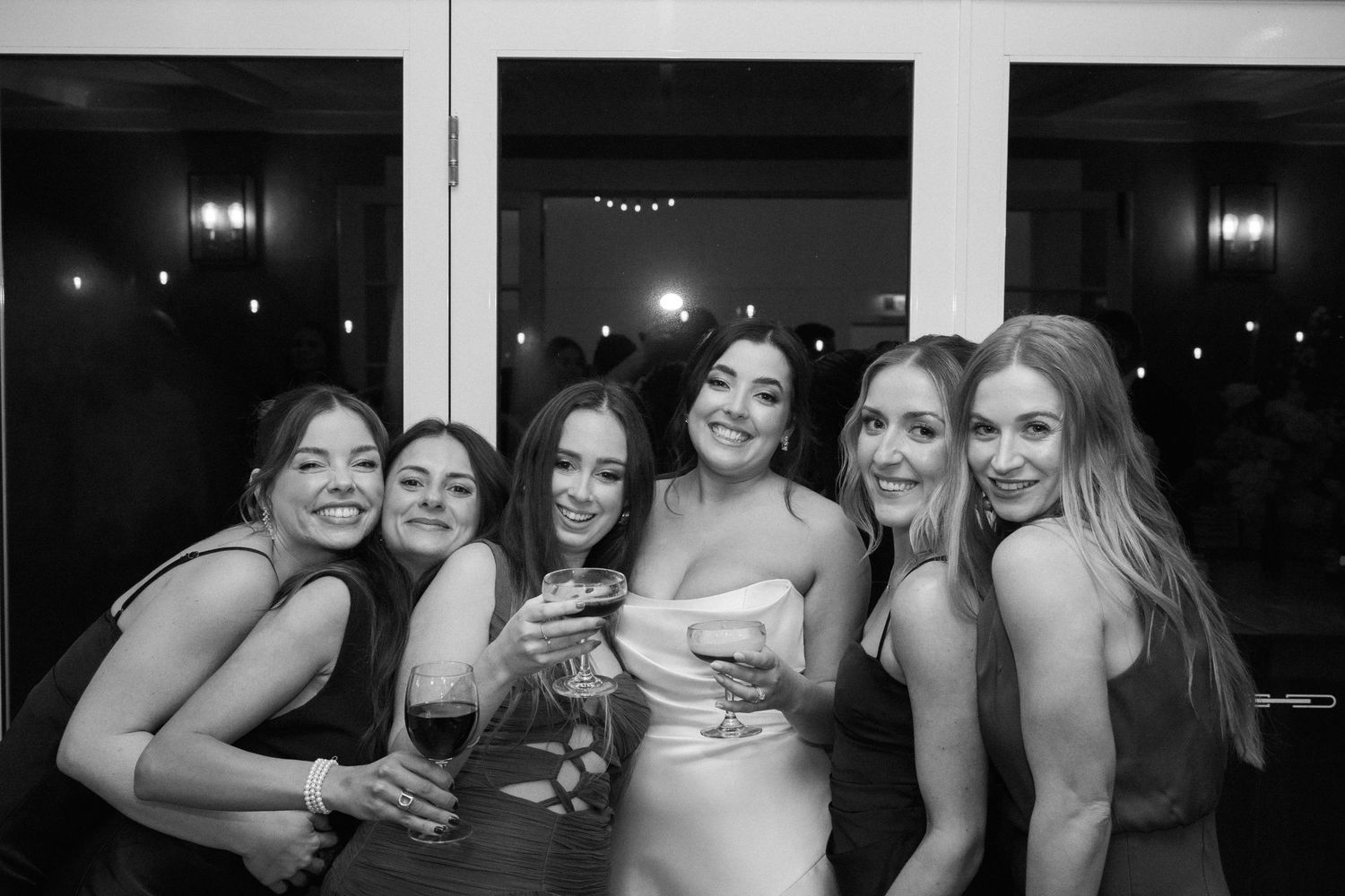 A celebratory group moment captured in black and white at a wedding reception.